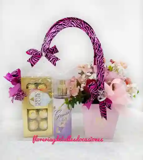 Novedoso Arreglo En Cartera Transparente Con Asa Con Bombones, Fragancia Y Detalle Floral